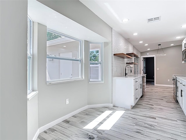 7140 Teaberry St, Englewood, FL 34224 - kitchen with stainless steel range with electric cooktop, light countertops, plenty of natural light, open shelves, and recessed lighting
