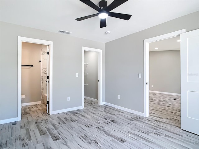 7140 Teaberry St, Englewood, FL 34224 - unfurnished bedroom with light wood-type flooring, baseboards, a spacious closet, a ceiling fan, and ensuite bath