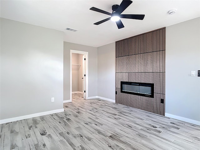 7140 Teaberry St, Englewood, FL 34224 - unfurnished living room featuring wood finished floors, ceiling fan, a glass covered fireplace, and baseboards