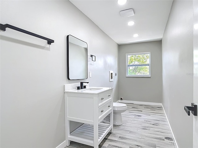 7140 Teaberry St, Englewood, FL 34224 - bathroom featuring toilet, vanity, baseboards, recessed lighting, and wood finished floors