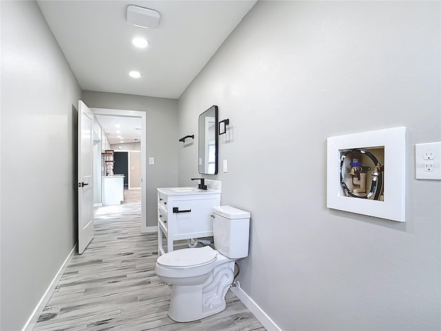 7140 Teaberry St, Englewood, FL 34224 - bathroom with toilet, wood finished floors, vanity, baseboards, and recessed lighting