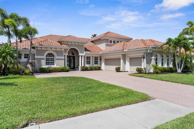 186 Portofino Dr, Nokomis, FL 34275 - mediterranean / spanish home with an attached garage, driveway, stucco siding, a front yard, and a tile roof