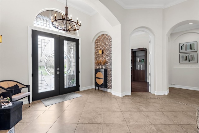 186 Portofino Dr, Nokomis, FL 34275 - foyer entrance with french doors, a chandelier, baseboards, light tile patterned floors, and arched walkways