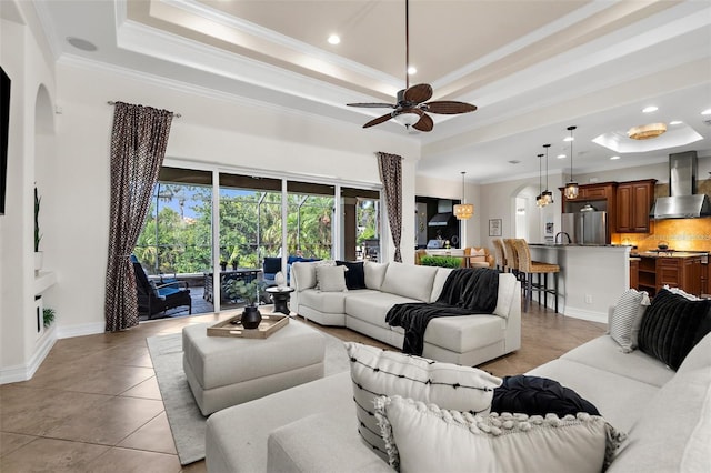 186 Portofino Dr, Nokomis, FL 34275 - living area featuring a tray ceiling, ornamental molding, a ceiling fan, arched walkways, and recessed lighting