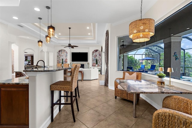 186 Portofino Dr, Nokomis, FL 34275 - kitchen featuring a ceiling fan, open floor plan, dark stone counters, a kitchen bar, and pendant lighting