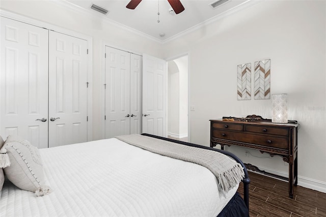 186 Portofino Dr, Nokomis, FL 34275 - bedroom featuring two closets, baseboards, dark wood-type flooring, crown molding, and a ceiling fan
