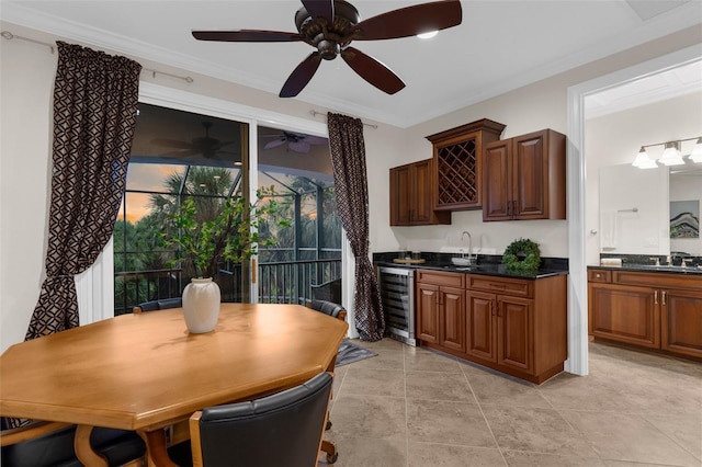 186 Portofino Dr, Nokomis, FL 34275 - kitchen with beverage cooler, dark countertops, ornamental molding, a ceiling fan, and a sink