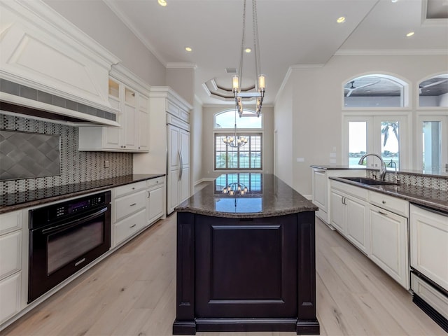 333 Sunrise Dr, Nokomis, FL 34275 - kitchen with oven, a sink, light wood-style floors, a chandelier, and a center island