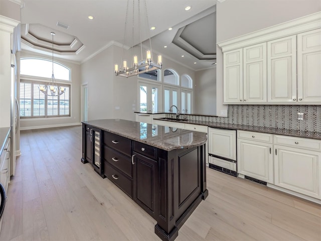 333 Sunrise Dr, Nokomis, FL 34275 - kitchen with a raised ceiling, a chandelier, beverage cooler, a sink, and tasteful backsplash