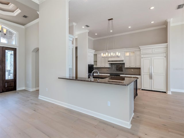 333 Sunrise Dr, Nokomis, FL 34275 - kitchen featuring ornamental molding, built in refrigerator, tasteful backsplash, dark stone counters, and white cabinetry