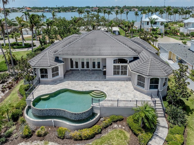 333 Sunrise Dr, Nokomis, FL 34275 - rear view of house featuring a tile roof, french doors, a patio area, stucco siding, and a fenced backyard