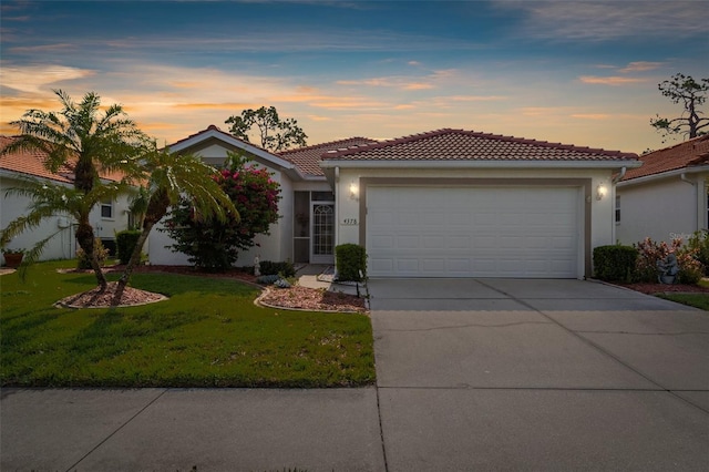 4378 Summertree Rd, Venice, FL 34293 - ranch-style house featuring driveway, an attached garage, a front yard, a tiled roof, and stucco siding
