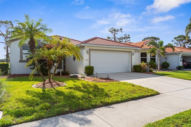 4378 Summertree Rd, Venice, FL 34293 - mediterranean / spanish home featuring stucco siding, a tiled roof, driveway, and a garage