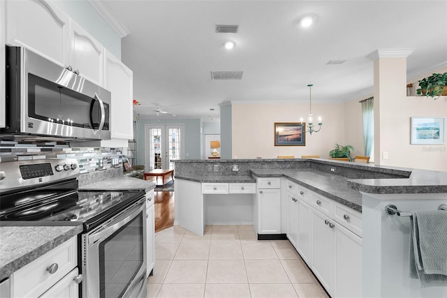 4378 Summertree Rd, Venice, FL 34293 - kitchen featuring appliances with stainless steel finishes, ornamental molding, a chandelier, dark countertops, and white cabinetry