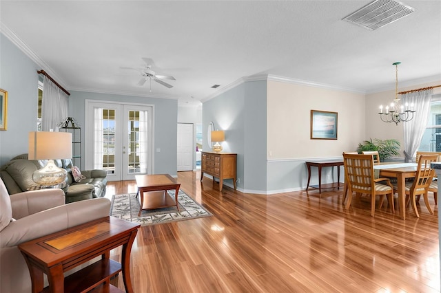4378 Summertree Rd, Venice, FL 34293 - living room featuring light wood-style flooring, a chandelier, baseboards, ornamental molding, and a ceiling fan