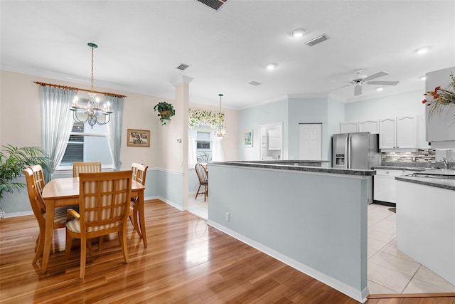 4378 Summertree Rd, Venice, FL 34293 - dining room featuring a chandelier, ceiling fan, baseboards, ornamental molding, and light wood-type flooring