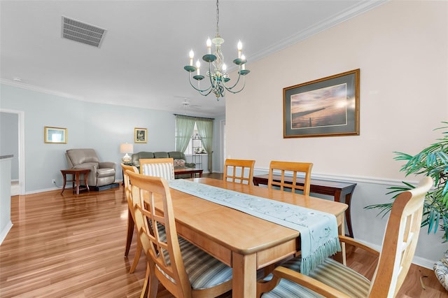 4378 Summertree Rd, Venice, FL 34293 - dining area with a chandelier, light wood-style flooring, baseboards, and ornamental molding