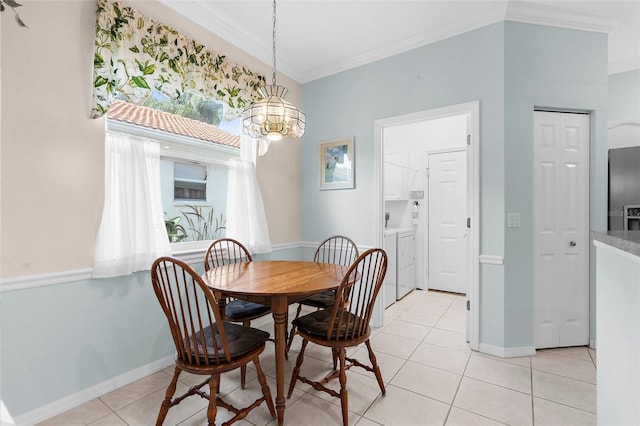 4378 Summertree Rd, Venice, FL 34293 - dining space featuring ornamental molding, light tile patterned flooring, a chandelier, baseboards, and washer and dryer