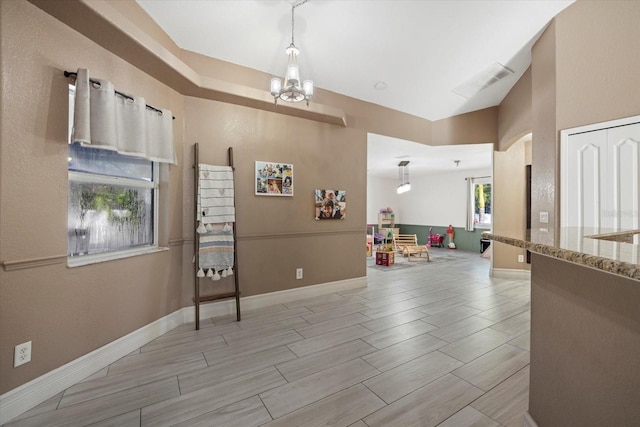 2769 Dode Ave, North Port, FL 34288 - interior space with a chandelier, wood finish floors, baseboards, and arched walkways