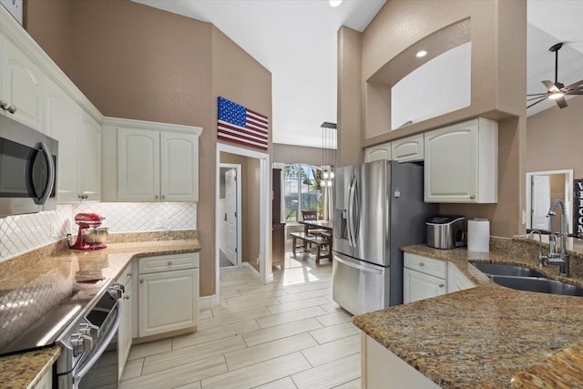 2769 Dode Ave, North Port, FL 34288 - kitchen with appliances with stainless steel finishes, a sink, a high ceiling, light stone counters, and decorative backsplash