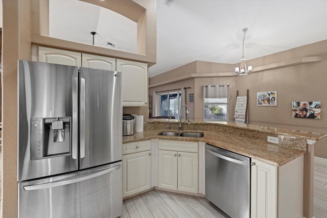 2769 Dode Ave, North Port, FL 34288 - kitchen featuring appliances with stainless steel finishes, a sink, a peninsula, a chandelier, and light stone counters