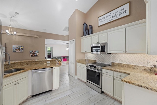 2769 Dode Ave, North Port, FL 34288 - kitchen with appliances with stainless steel finishes, a sink, backsplash, light stone counters, and white cabinets