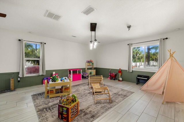 2769 Dode Ave, North Port, FL 34288 - playroom with wainscoting, plenty of natural light, light wood-style floors, and wooden walls