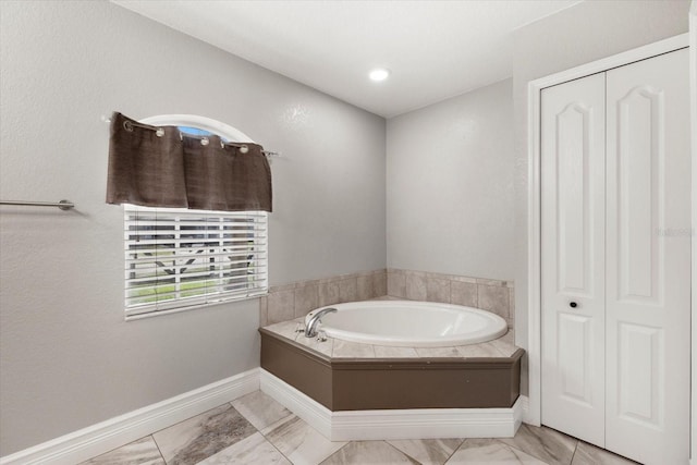 2769 Dode Ave, North Port, FL 34288 - full bath with a garden tub, baseboards, marble look tiles, and a closet