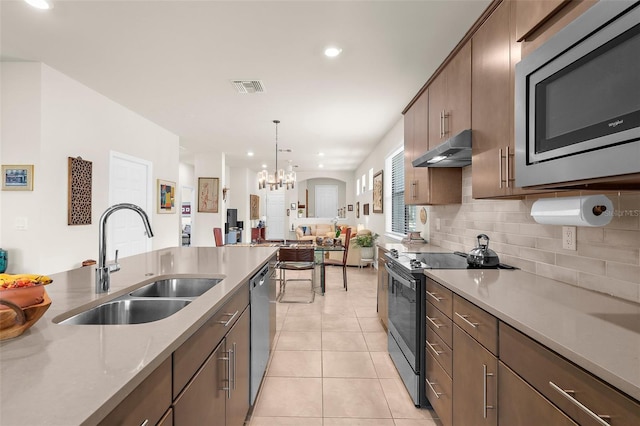 13486 Nobilio St, Venice, FL 34293 - kitchen featuring appliances with stainless steel finishes, under cabinet range hood, recessed lighting, tasteful backsplash, and a chandelier