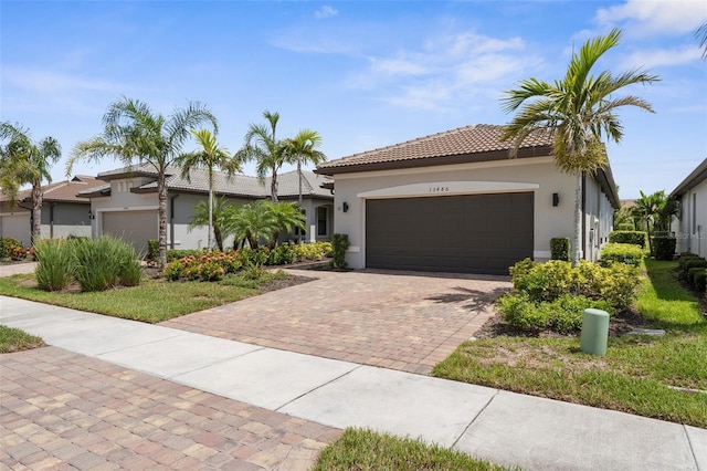 13486 Nobilio St, Venice, FL 34293 - view of front of property with stucco siding, decorative driveway, an attached garage, and a tiled roof