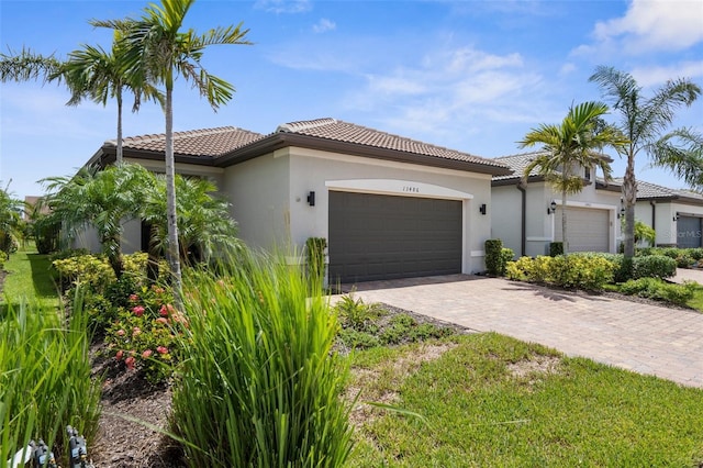 13486 Nobilio St, Venice, FL 34293 - mediterranean / spanish house with an attached garage, a tile roof, and stucco siding