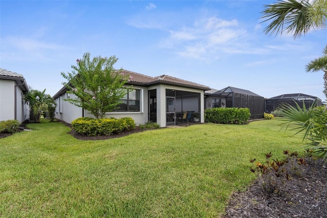 13486 Nobilio St, Venice, FL 34293 - rear view of house featuring a tiled roof, stucco siding, and a yard