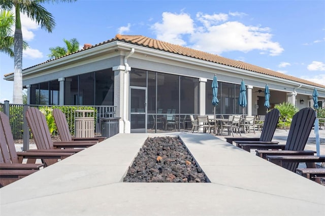 13486 Nobilio St, Venice, FL 34293 - rear view of house featuring ceiling fan, a tiled roof, a sunroom, a patio area, and outdoor dining space
