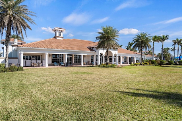 13486 Nobilio St, Venice, FL 34293 - back of house featuring a tile roof, a yard, a patio area, and stucco siding