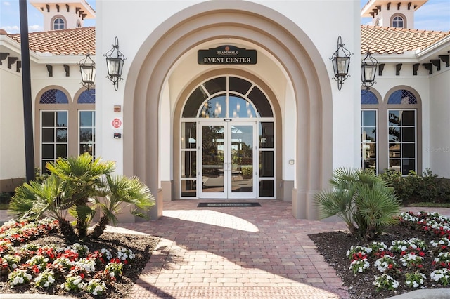 13486 Nobilio St, Venice, FL 34293 - view of exterior entry with french doors, stucco siding, and a tile roof