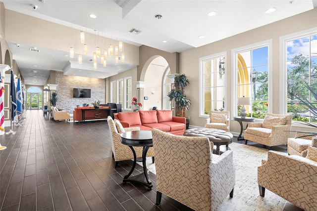 13486 Nobilio St, Venice, FL 34293 - living area with arched walkways, dark wood-style flooring, and recessed lighting