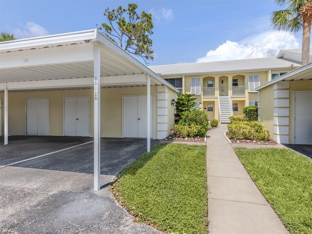 418 Cerromar Ct Unit 158, Venice, FL 34293 - view of front of property with stucco siding, covered parking, and a front yard