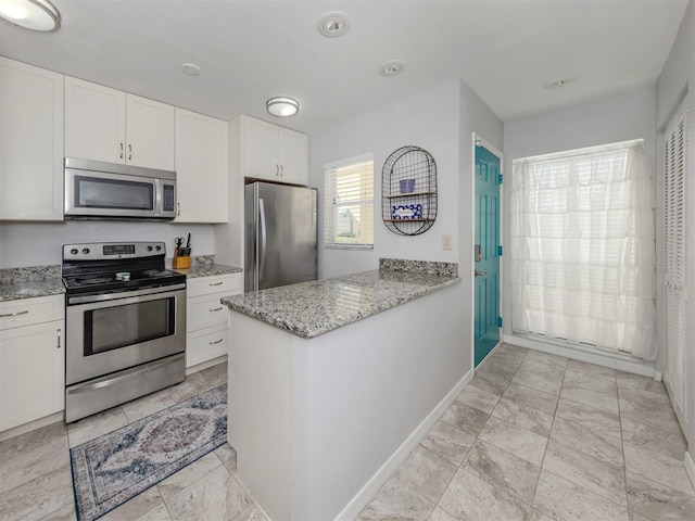 418 Cerromar Ct Unit 158, Venice, FL 34293 - kitchen with stainless steel appliances, white cabinets, light stone counters, baseboards, and a peninsula