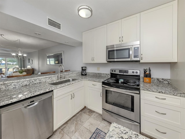 418 Cerromar Ct Unit 158, Venice, FL 34293 - kitchen featuring stainless steel appliances, a sink, white cabinetry, and light stone countertops