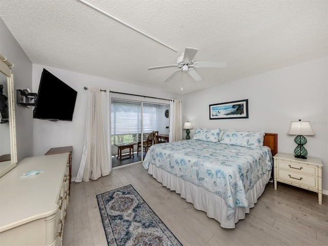 418 Cerromar Ct Unit 158, Venice, FL 34293 - bedroom featuring access to exterior, light wood-style floors, a textured ceiling, baseboards, and ceiling fan