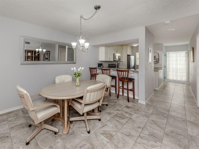 418 Cerromar Ct Unit 158, Venice, FL 34293 - dining room featuring a chandelier, a textured ceiling, and baseboards