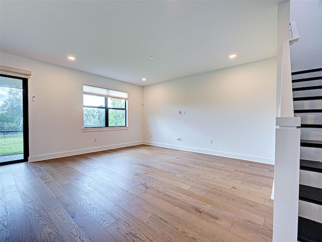 12705 Pinnacle Ln, Venice, FL 34293 - empty room featuring wood finished floors, baseboards, recessed lighting, and stairway