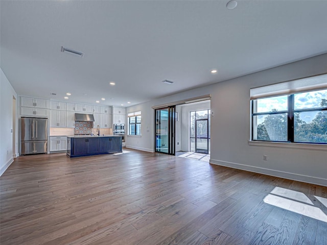 12705 Pinnacle Ln, Venice, FL 34293 - unfurnished living room featuring recessed lighting, dark wood-style floors, baseboards, and a sink