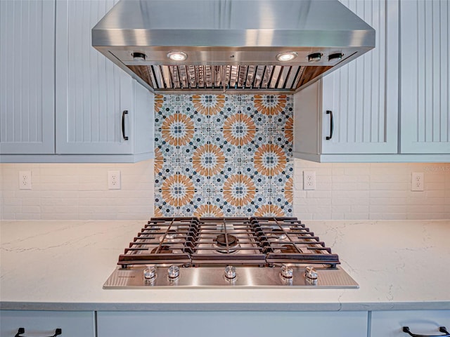 12705 Pinnacle Ln, Venice, FL 34293 - kitchen with under cabinet range hood, stainless steel gas stovetop, backsplash, and light stone countertops