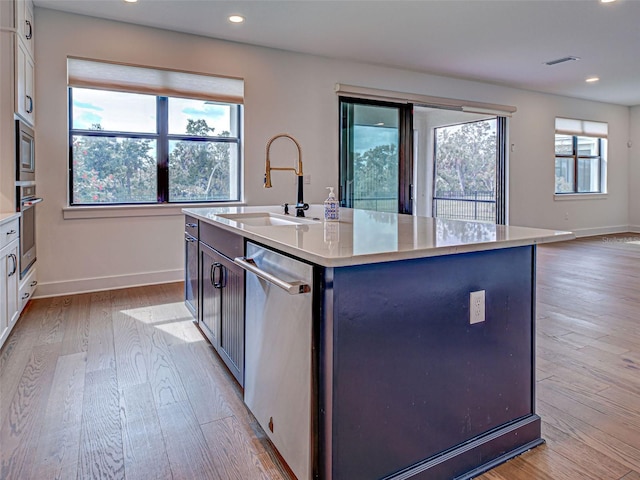 12705 Pinnacle Ln, Venice, FL 34293 - kitchen featuring appliances with stainless steel finishes, a sink, baseboards, light wood finished floors, and light countertops