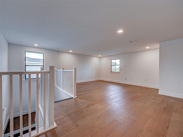 12705 Pinnacle Ln, Venice, FL 34293 - empty room featuring light wood finished floors, recessed lighting, baseboards, and a textured ceiling