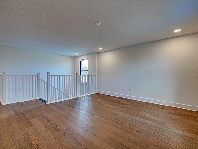 12705 Pinnacle Ln, Venice, FL 34293 - unfurnished room with hardwood / wood-style floors, a textured ceiling, baseboards, and recessed lighting