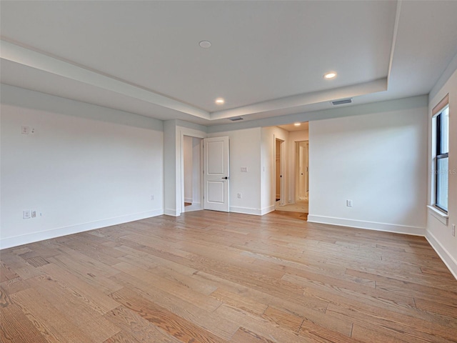 12705 Pinnacle Ln, Venice, FL 34293 - spare room featuring a tray ceiling, light wood finished floors, baseboards, and recessed lighting