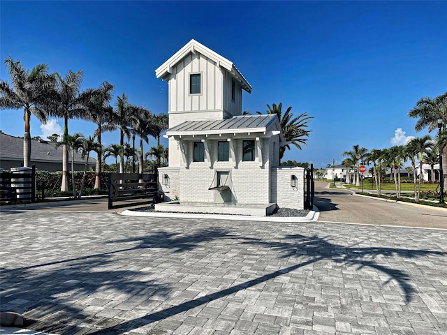 12705 Pinnacle Ln, Venice, FL 34293 - view of front facade with brick siding, board and batten siding, metal roof, and a standing seam roof