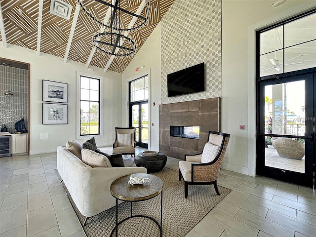 12705 Pinnacle Ln, Venice, FL 34293 - living room with high vaulted ceiling, wine cooler, a tile fireplace, baseboards, and light tile patterned floors
